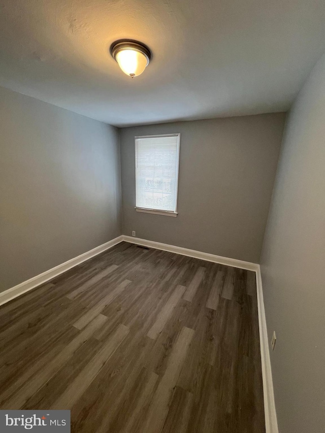 spare room with dark hardwood / wood-style flooring