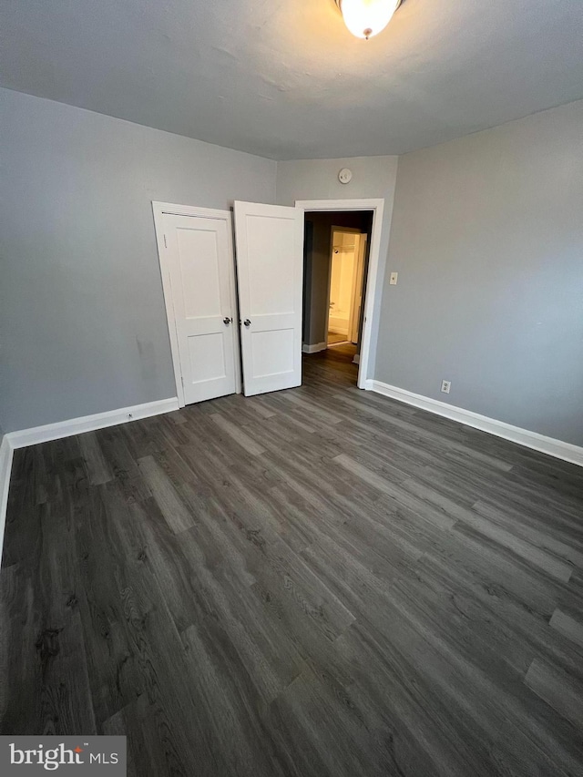 unfurnished bedroom featuring dark hardwood / wood-style flooring