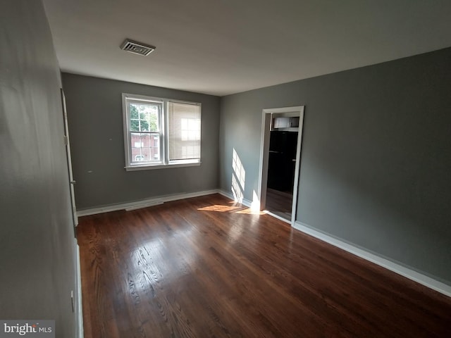 spare room with dark hardwood / wood-style floors