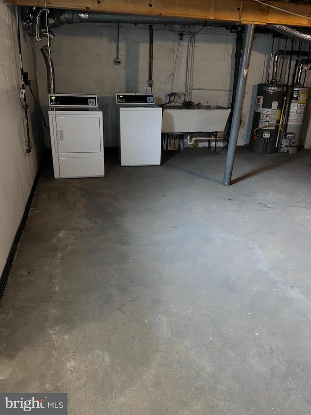 basement featuring separate washer and dryer, sink, and water heater