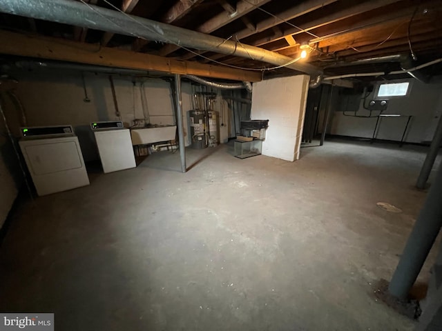 basement with water heater, sink, and independent washer and dryer