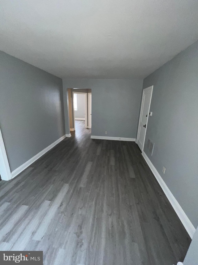 empty room with dark hardwood / wood-style flooring