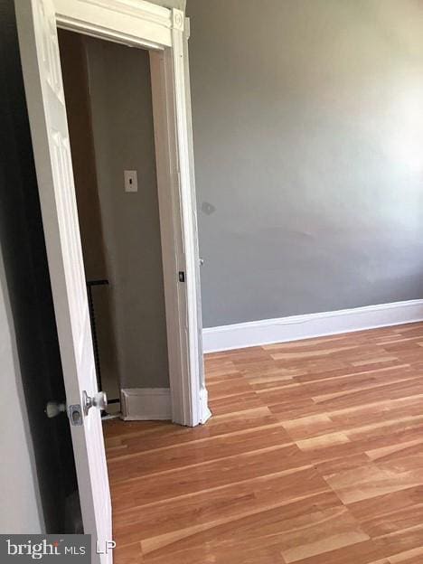 hallway with hardwood / wood-style floors