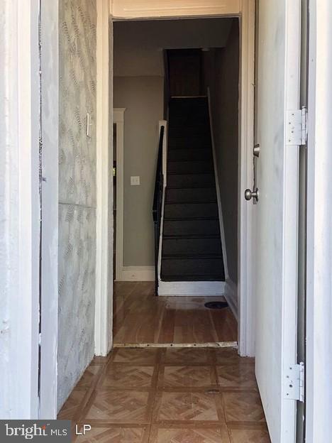 stairway featuring parquet flooring