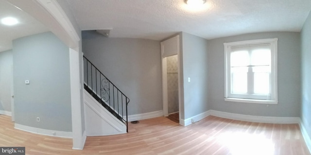 entryway with light hardwood / wood-style flooring and a textured ceiling