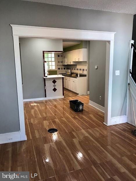 interior space with a textured ceiling and dark hardwood / wood-style flooring