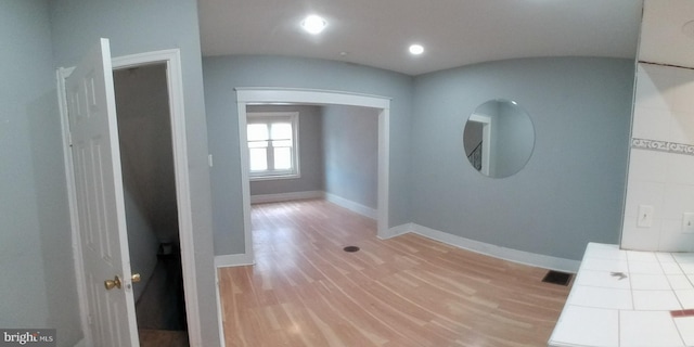 corridor with hardwood / wood-style flooring