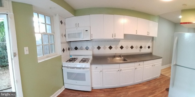 kitchen with sink, white appliances, white cabinets, and hardwood / wood-style flooring