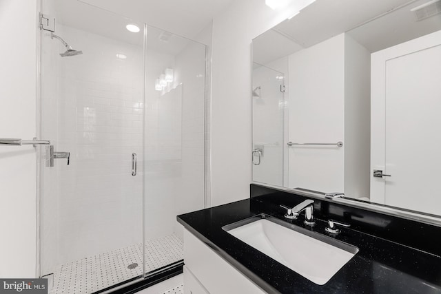 bathroom featuring vanity and a shower with shower door