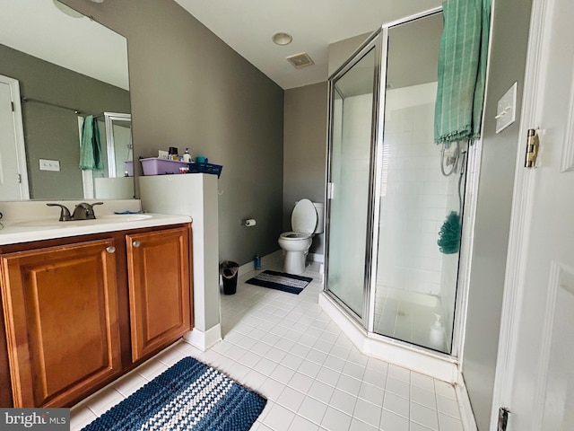 bathroom with vanity, toilet, tile patterned floors, and walk in shower