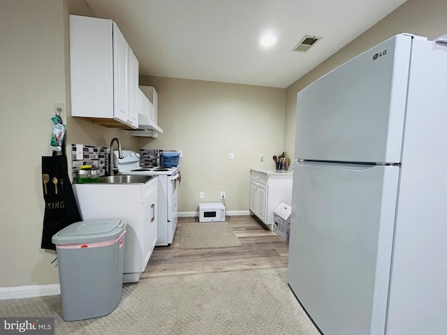 laundry area featuring sink and light hardwood / wood-style floors