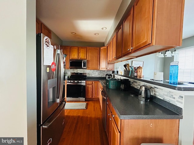 kitchen featuring dark wood-type flooring, appliances with stainless steel finishes, and tasteful backsplash