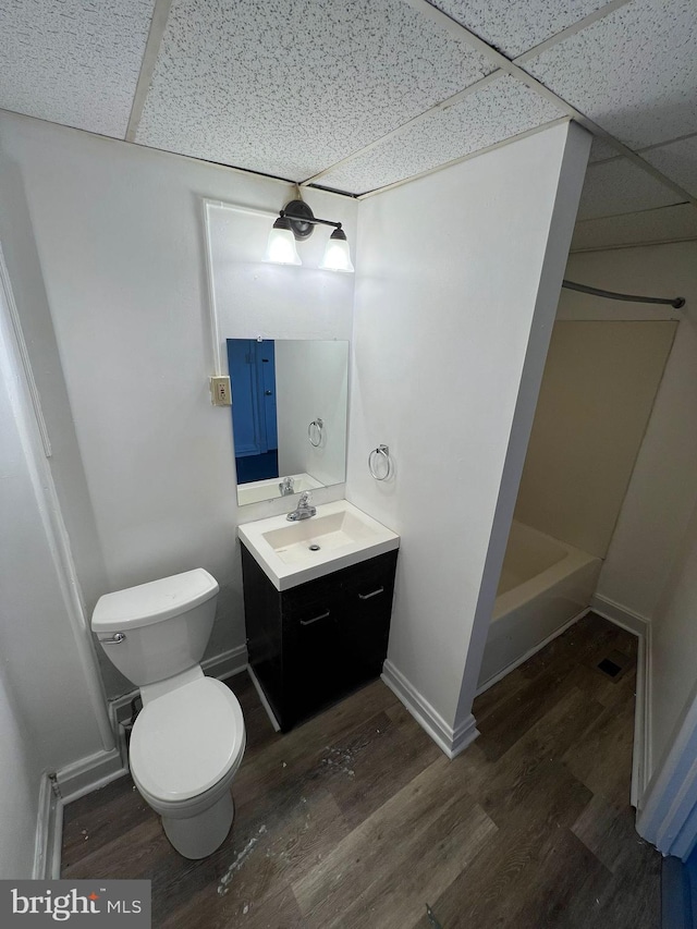 bathroom featuring vanity, hardwood / wood-style floors, a paneled ceiling, and toilet