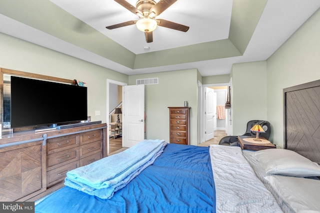 bedroom featuring a raised ceiling and ceiling fan