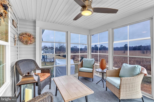 sunroom / solarium with a rural view, wood ceiling, and ceiling fan