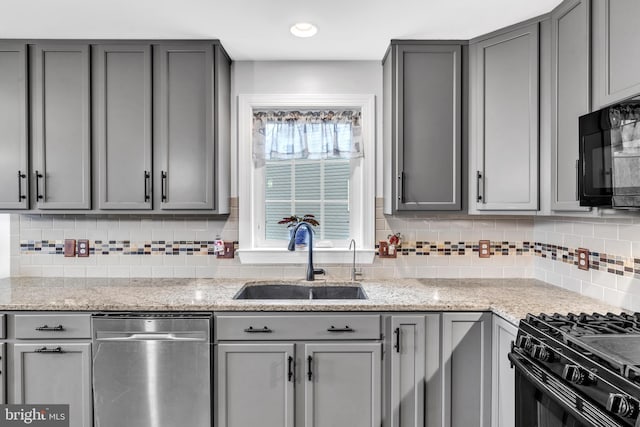 kitchen with sink, gray cabinets, black appliances, and light stone countertops