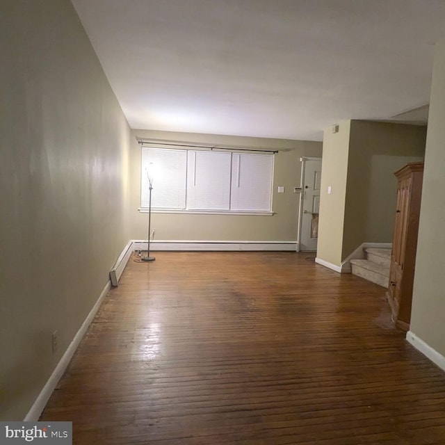 spare room with dark hardwood / wood-style floors and a baseboard radiator