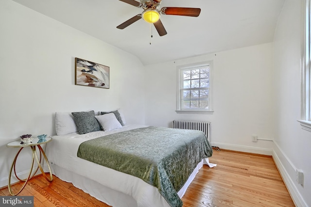 bedroom featuring ceiling fan, wood-type flooring, radiator, and vaulted ceiling