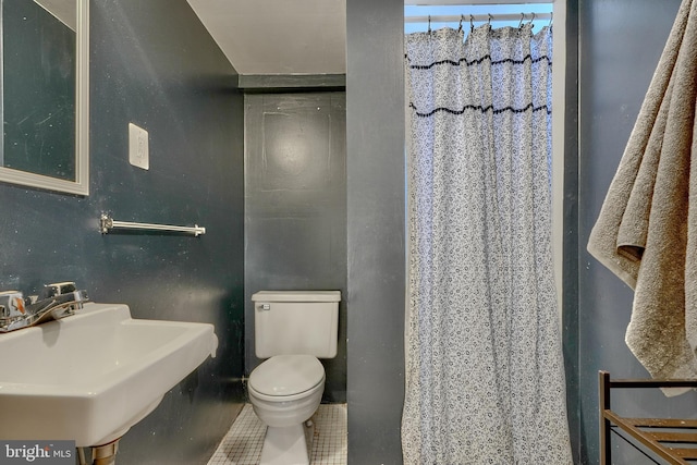 bathroom featuring sink, a shower with shower curtain, tile patterned floors, and toilet