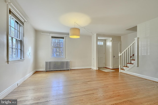 spare room with radiator and light hardwood / wood-style floors