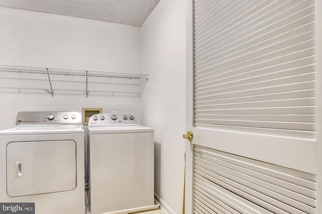 washroom featuring washing machine and clothes dryer and a textured ceiling