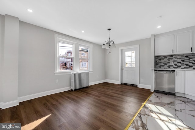 interior space with dark wood-type flooring, radiator heating unit, and a chandelier