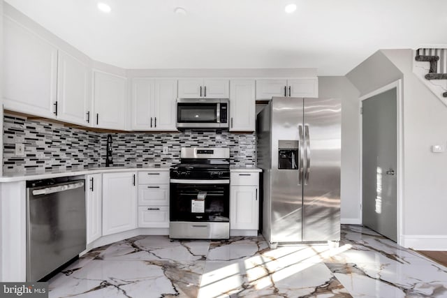 kitchen featuring stainless steel appliances, white cabinetry, sink, and decorative backsplash