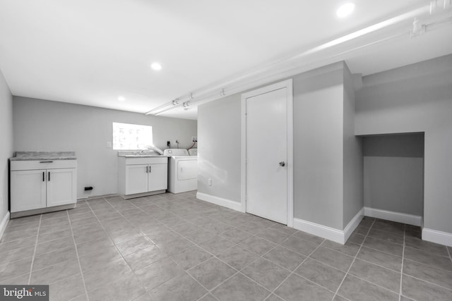 laundry room with light tile patterned flooring, cabinets, and washing machine and clothes dryer