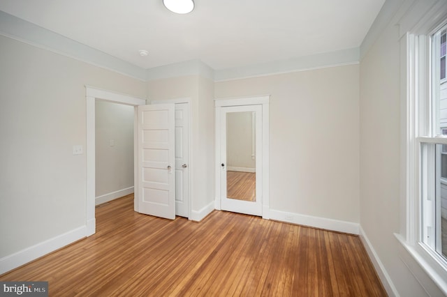 unfurnished bedroom with crown molding and hardwood / wood-style floors