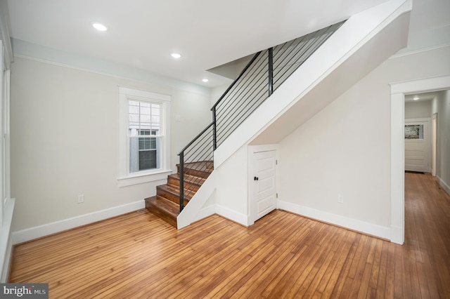 stairway featuring crown molding and hardwood / wood-style floors