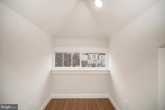 additional living space with wood-type flooring and vaulted ceiling