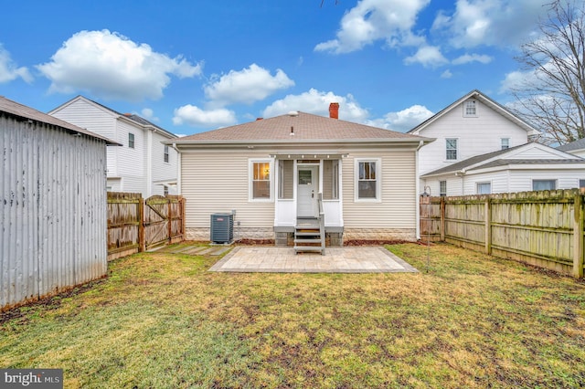 rear view of house featuring a yard, a patio, and central air condition unit