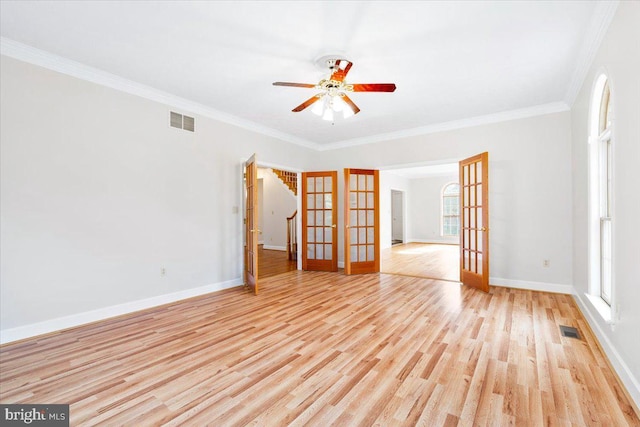 unfurnished room with light wood-type flooring, french doors, visible vents, and a healthy amount of sunlight