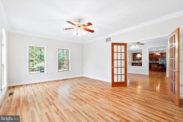 spare room with light wood finished floors, french doors, and visible vents