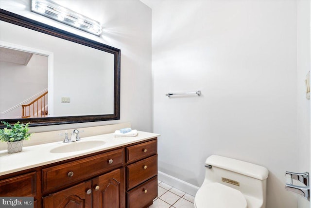 bathroom featuring baseboards, vanity, toilet, and tile patterned floors