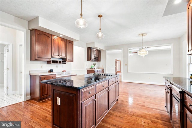 kitchen featuring pendant lighting, a kitchen island, and light wood-style flooring