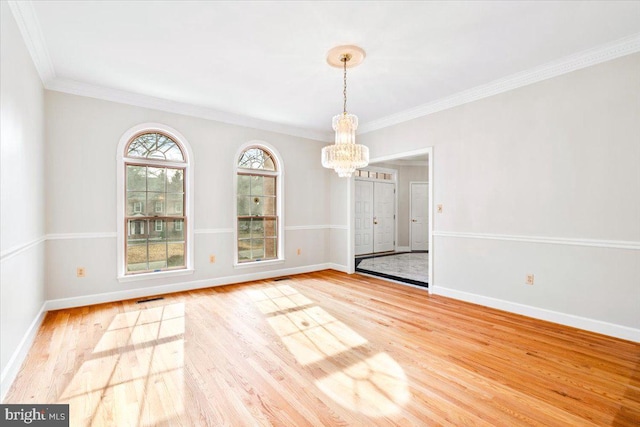 unfurnished dining area featuring an inviting chandelier, visible vents, baseboards, and wood finished floors