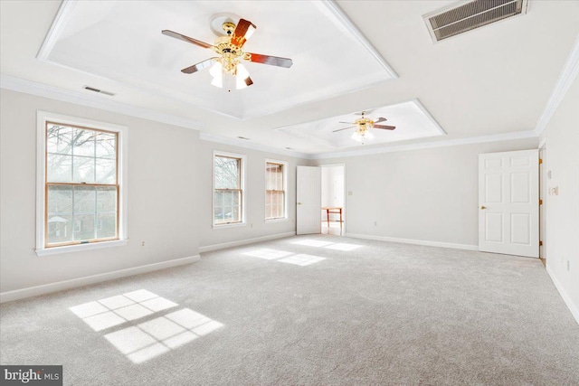 empty room featuring baseboards, crown molding, visible vents, and a tray ceiling