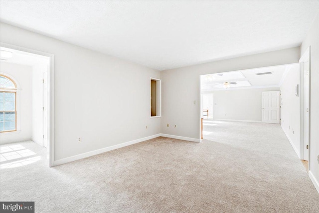 unfurnished room with baseboards, a ceiling fan, and light colored carpet