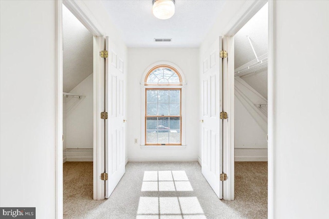 corridor with light carpet and visible vents