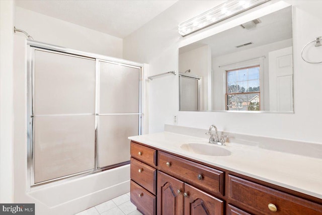 bathroom featuring visible vents, bath / shower combo with glass door, vanity, and tile patterned floors