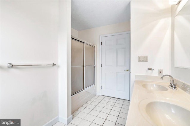 bathroom with double vanity, tile patterned flooring, bath / shower combo with glass door, and a sink