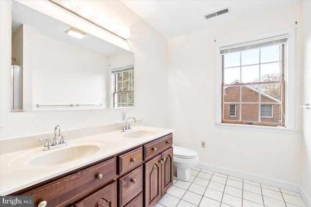 bathroom with visible vents, a sink, toilet, and double vanity