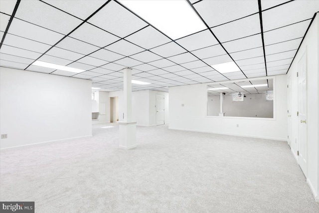 finished basement with light carpet, a drop ceiling, and baseboards