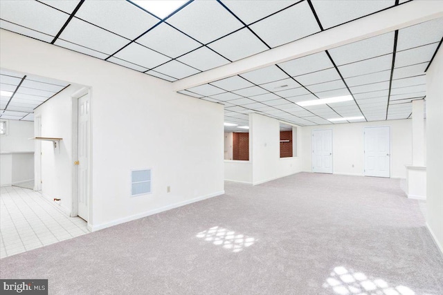 interior space featuring light carpet, baseboards, visible vents, and a paneled ceiling