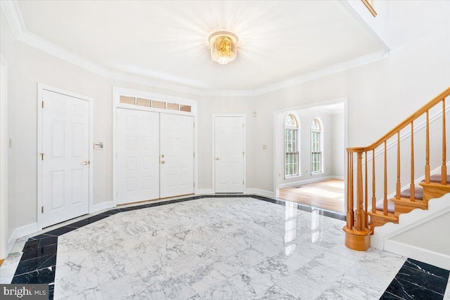 foyer entrance with marble finish floor, crown molding, baseboards, and stairs