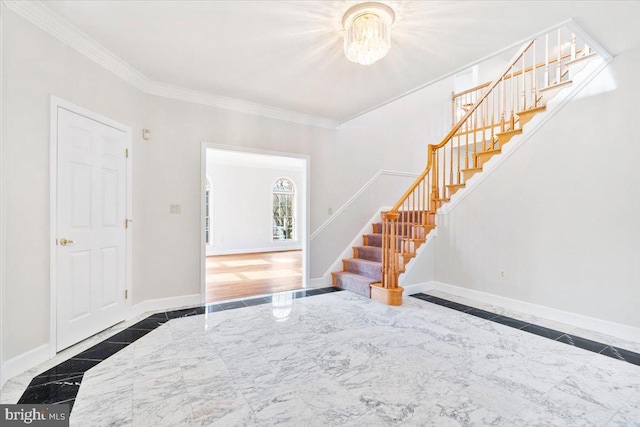 entrance foyer with ornamental molding, marble finish floor, baseboards, and stairs