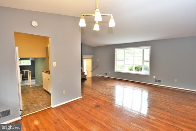 unfurnished living room with hardwood / wood-style flooring and vaulted ceiling