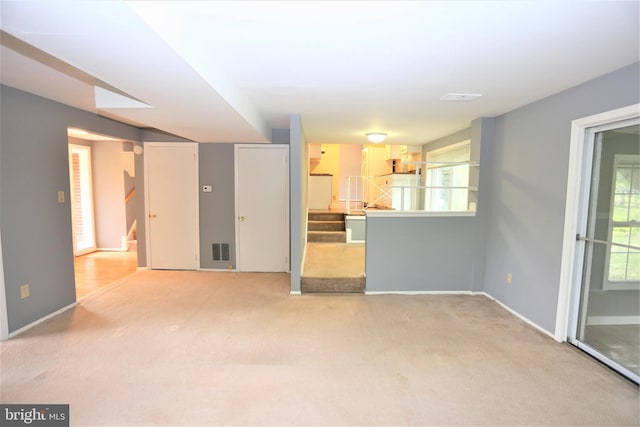 unfurnished living room with carpet and a healthy amount of sunlight