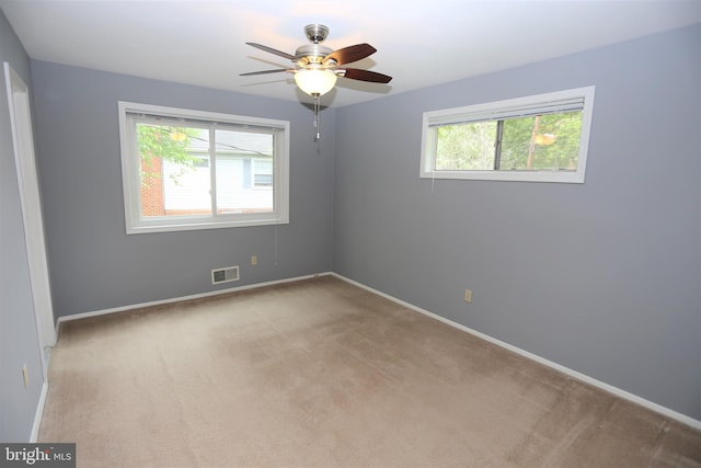 carpeted empty room featuring plenty of natural light and ceiling fan